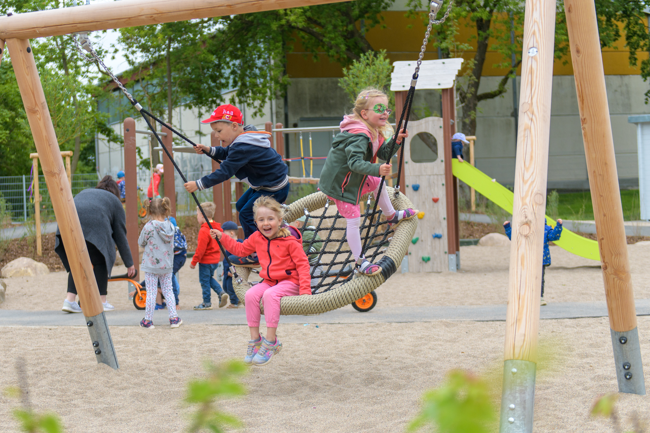 Der neue Außenbereich bietet viel Platz zum Toben – ob wie hier beim Schaukeln oder auf der Rutsche sowie der Rollerstrecke